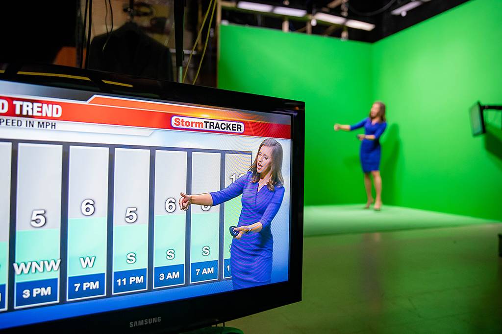 Lydia Blume works in front of a green screen delivering weather